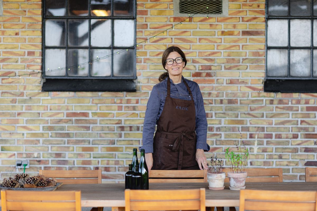 Vibeke at the long table under the covered terrace at Æblevig in Vig